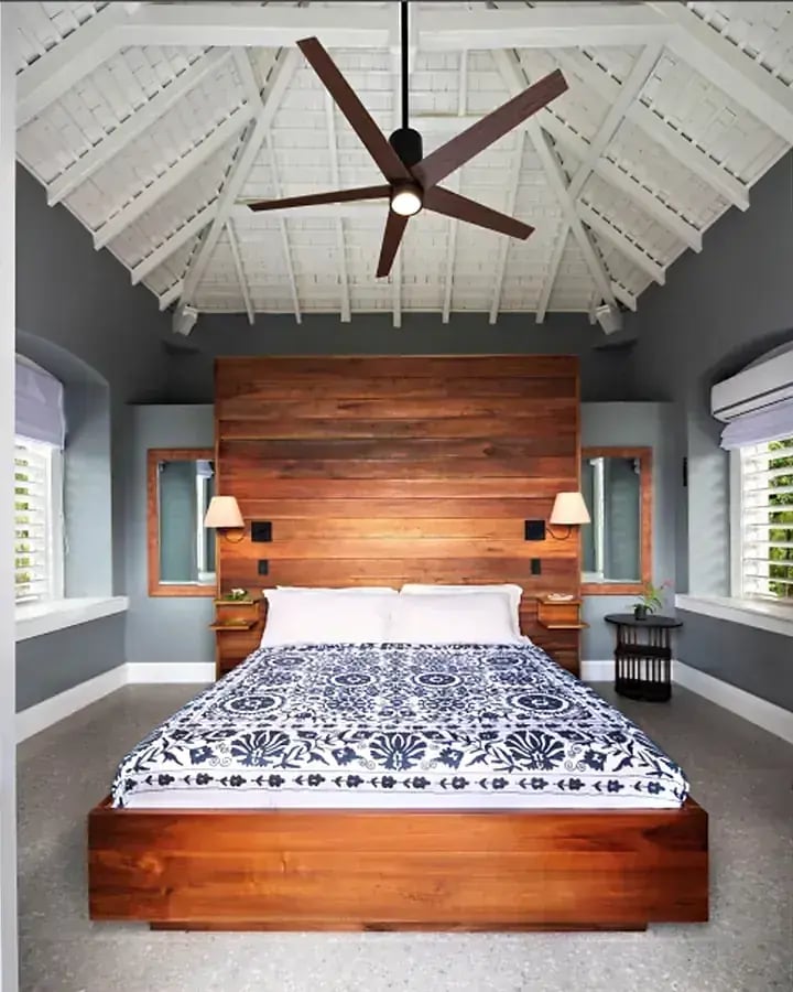 A bedroom with a wooden headboard and ceiling fan